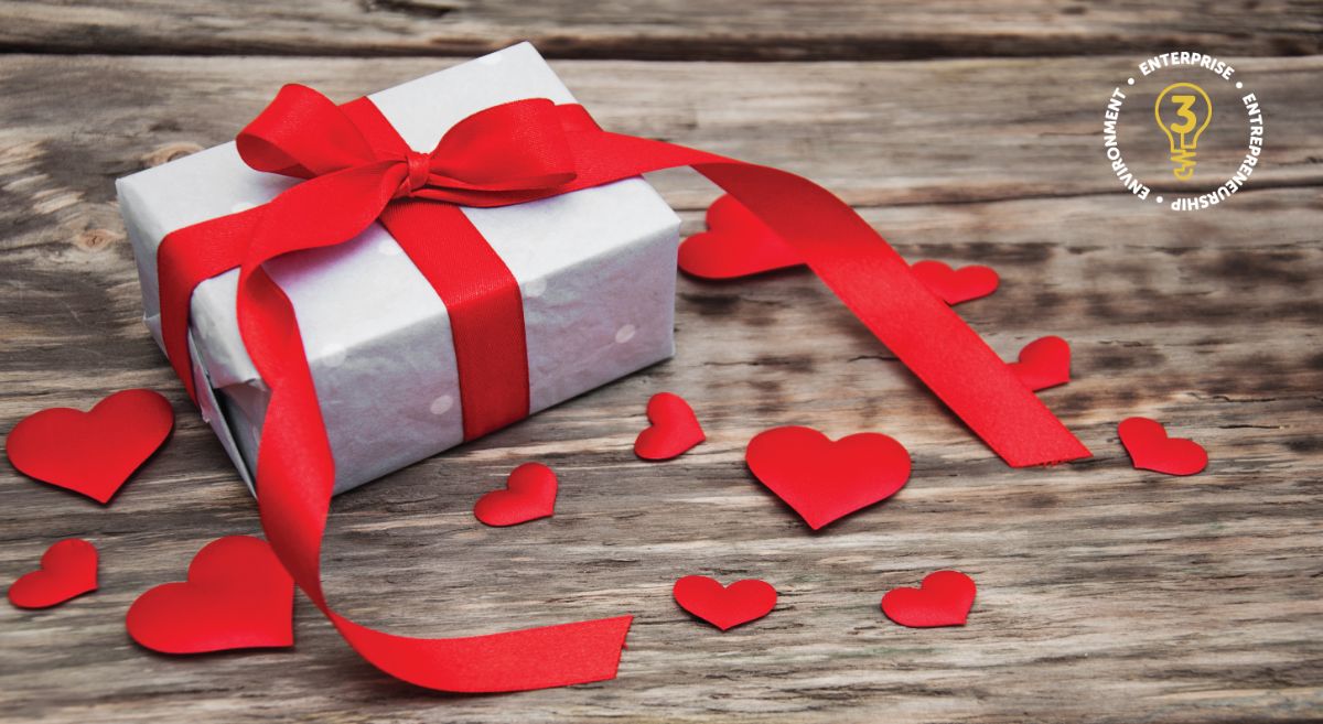 Stock picture showing a box wrapped in red rippon with red hearts on a wooden table